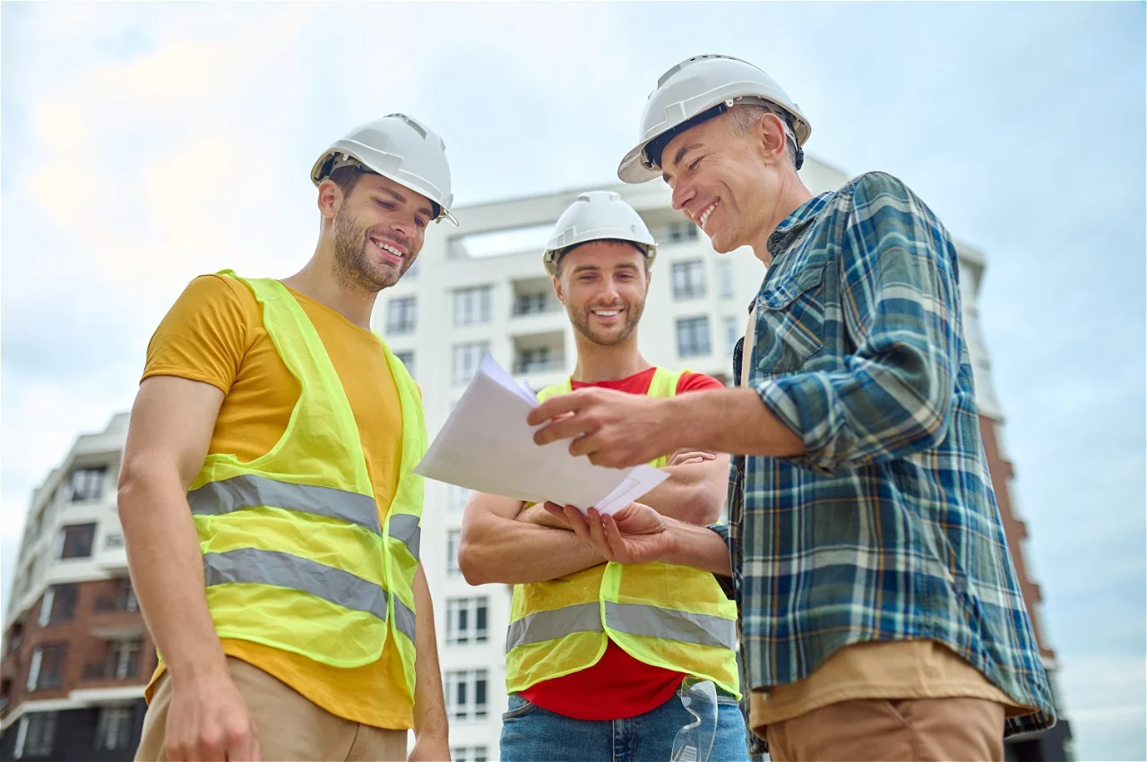 three-men-with-drawing-discussing-construction-site lexmo